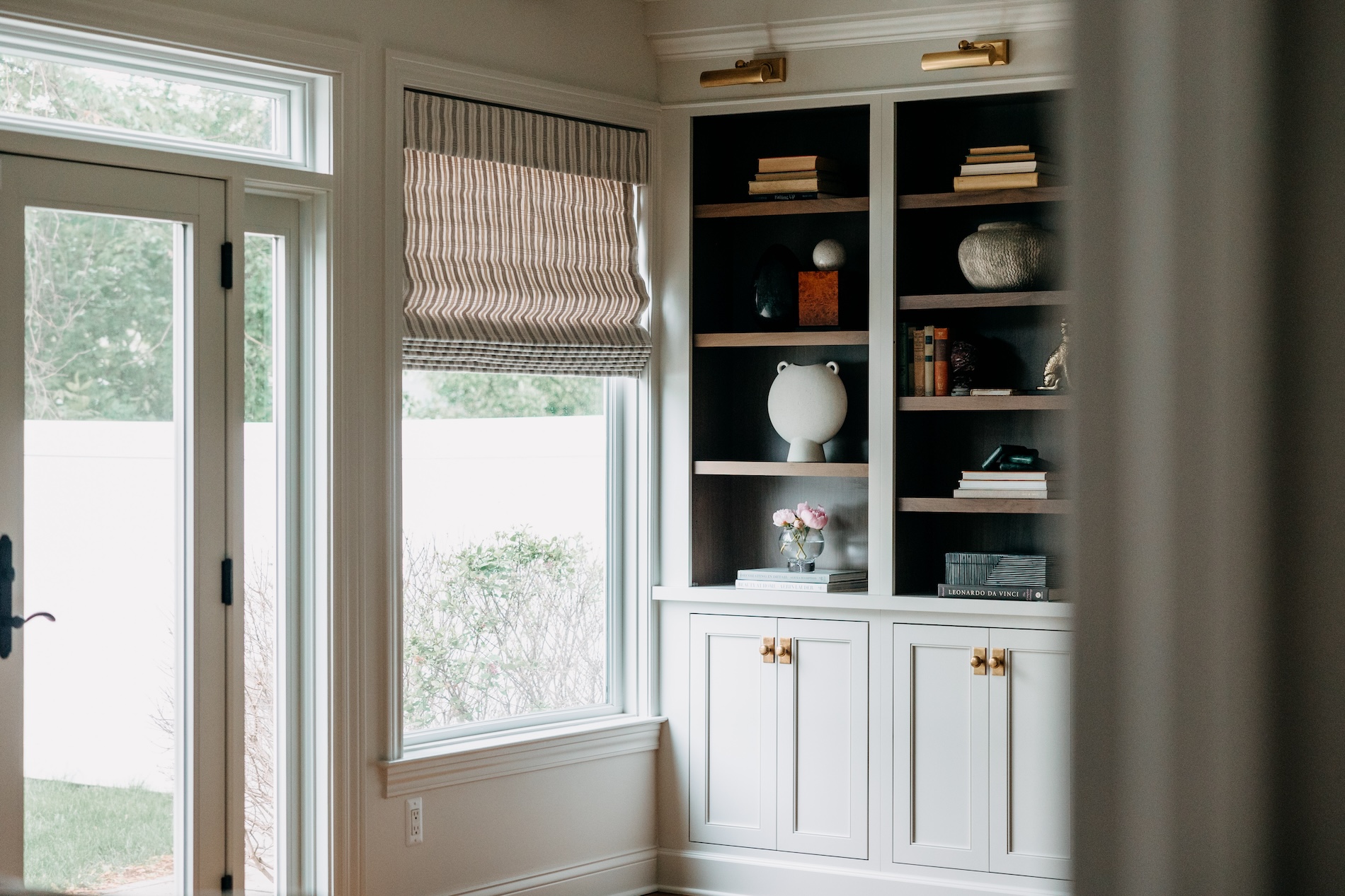 living room shelves with sliding door and window treatments